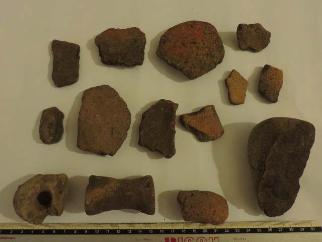 FRammenti in terracotta con ansa rocchetto e macinello in pierta verde